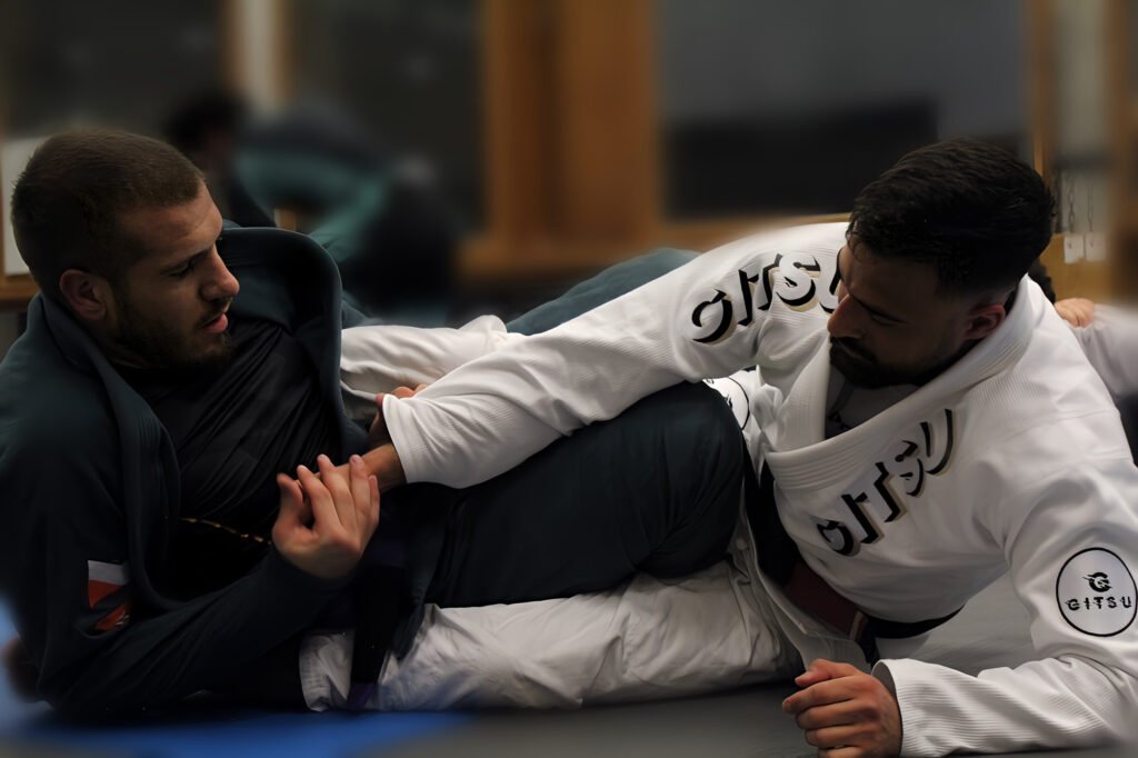 Coach Abderrahman enseignant les techniques de Jiu-Jitsu brésilien à un apprenti lors d’un entraînement pratique, mettant en lumière l’art martial au sol.