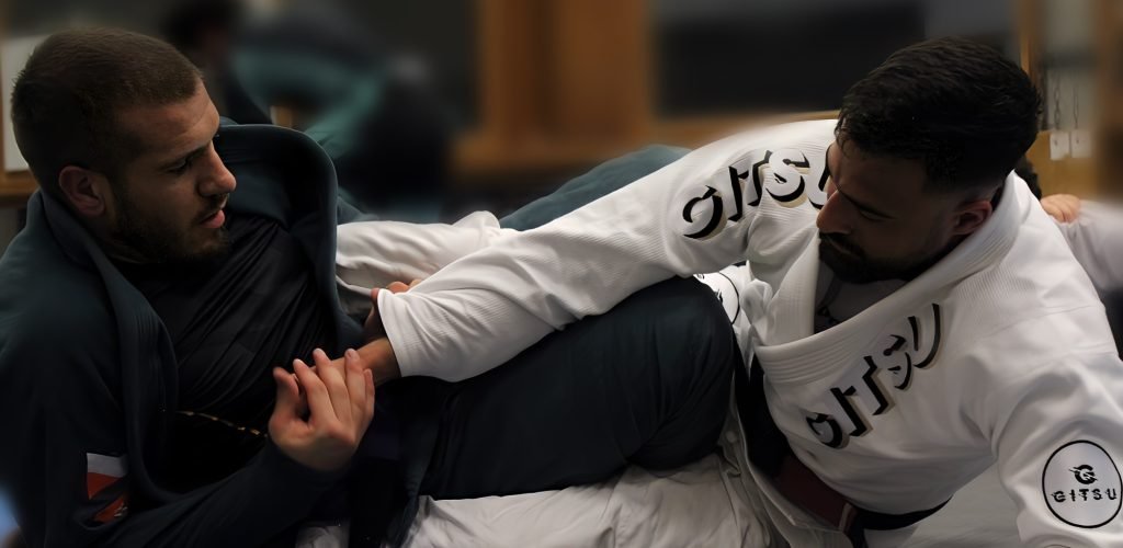 Coach Abderrahman enseignant les techniques de Jiu-Jitsu brésilien à un apprenti lors d’un entraînement pratique, mettant en lumière l’art martial au sol.